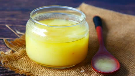 ghee in a glass jar with wooden spoon