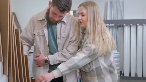 a young family is looking at exhibition samples of laminate in a building materials supermarket