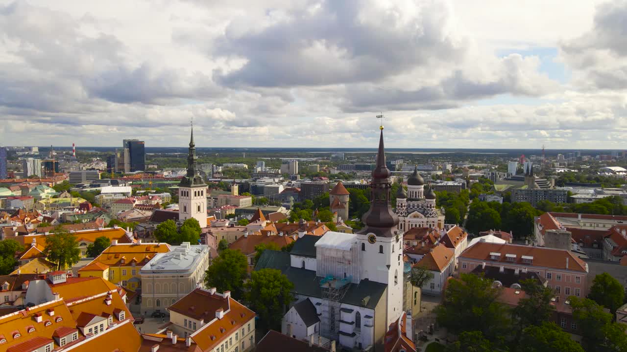 Aerial drone footage revealing historic European Tallinn capital city medieval buildings and old white church towers during a sunny summer day by flying over them. beautiful Unesco world heritage city