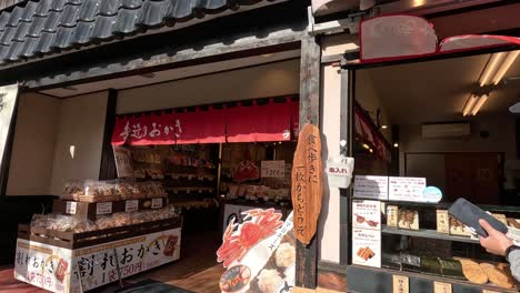 a person walks by a quaint japanese storefront.