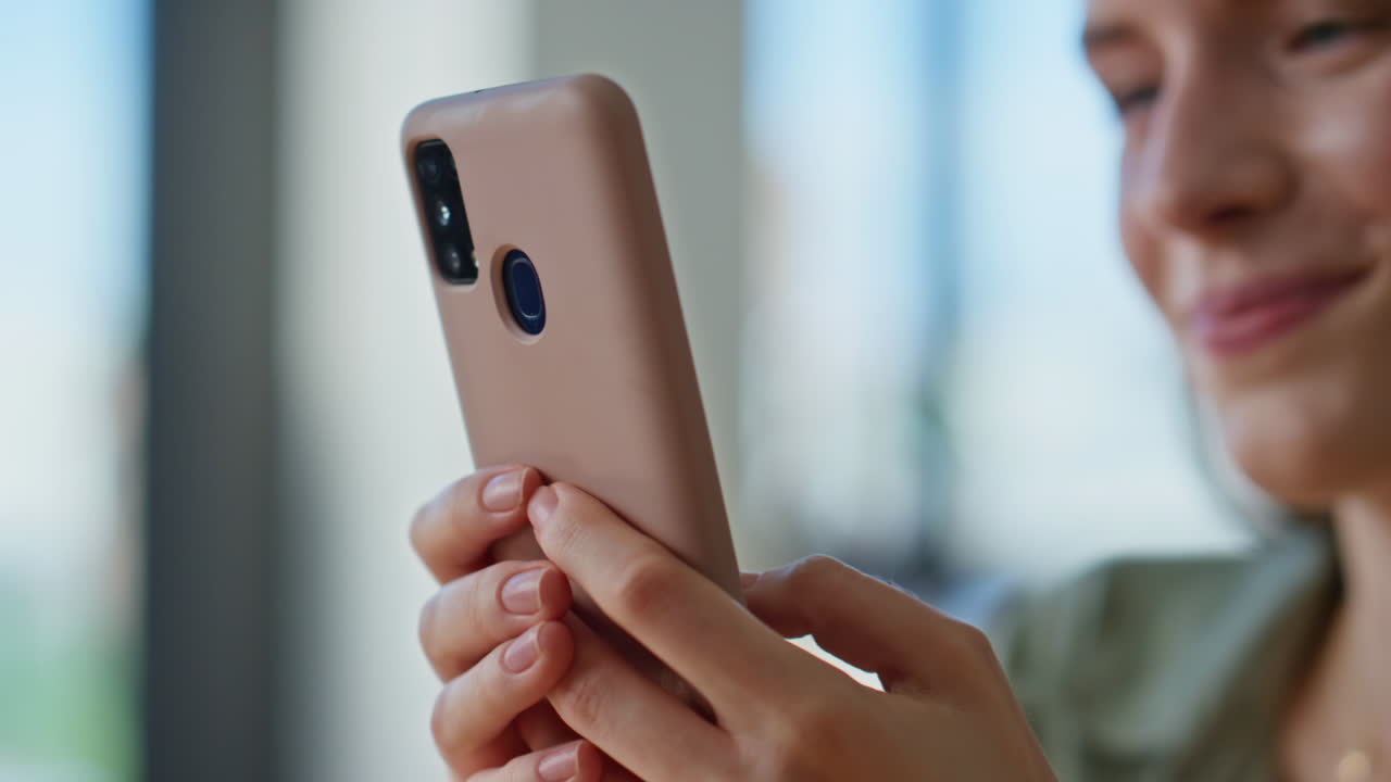 Woman hands texting cellphone in modern apartment closeup. Smiling lady browsing
