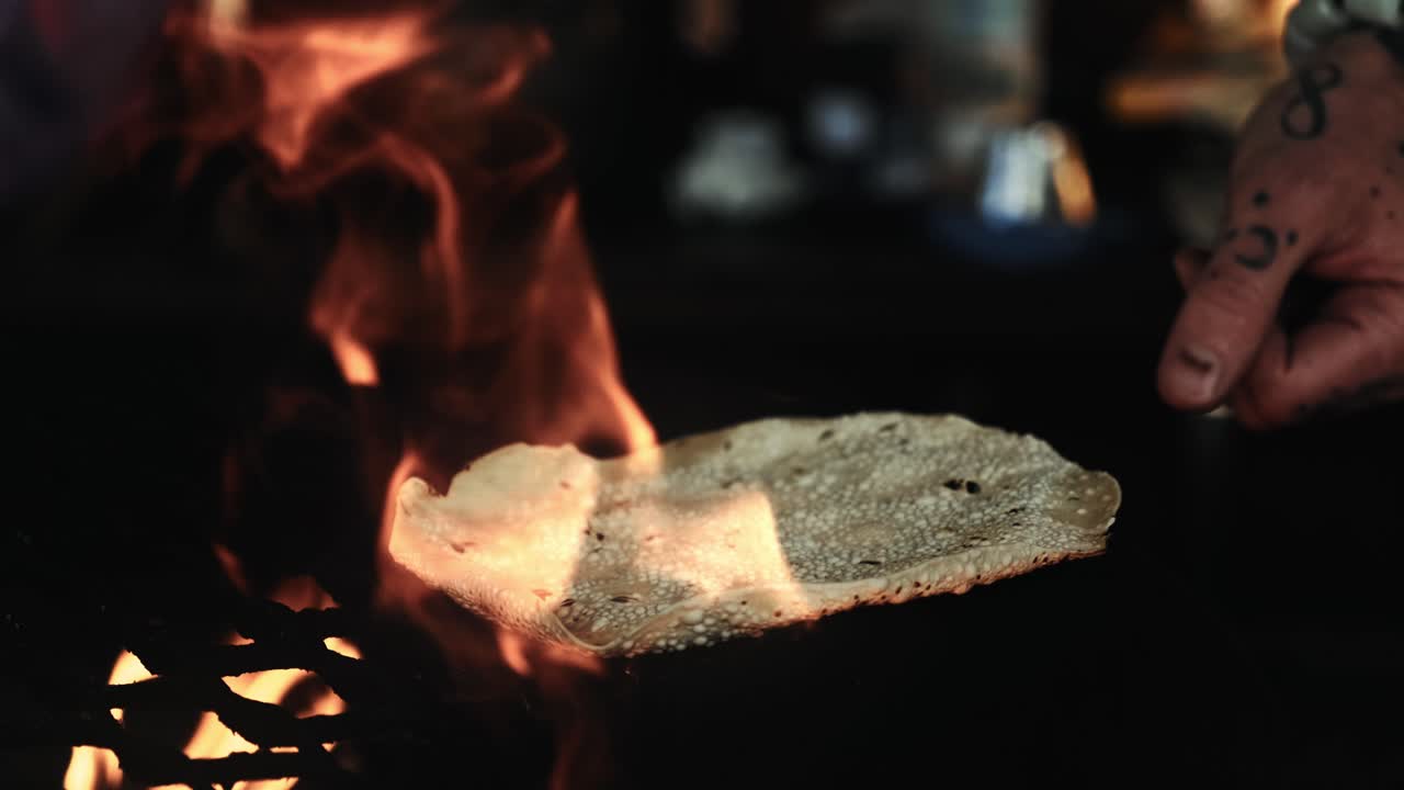 파파담 플래트 브레드 (papadam flat bread over fire pit with flames cooking, outdoor kitchen cooking with hand grabbing dough) 는 불꽃으로 는 구이, 야외 부에서 손으로 은 반죽을 조리하는 방법이다.