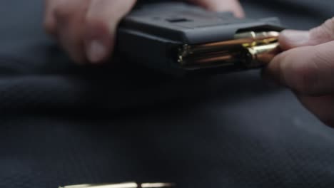 persona cargando balas en un cargador de armas de fuego