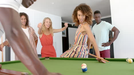 diverse group of friends enjoy a game of pool at home