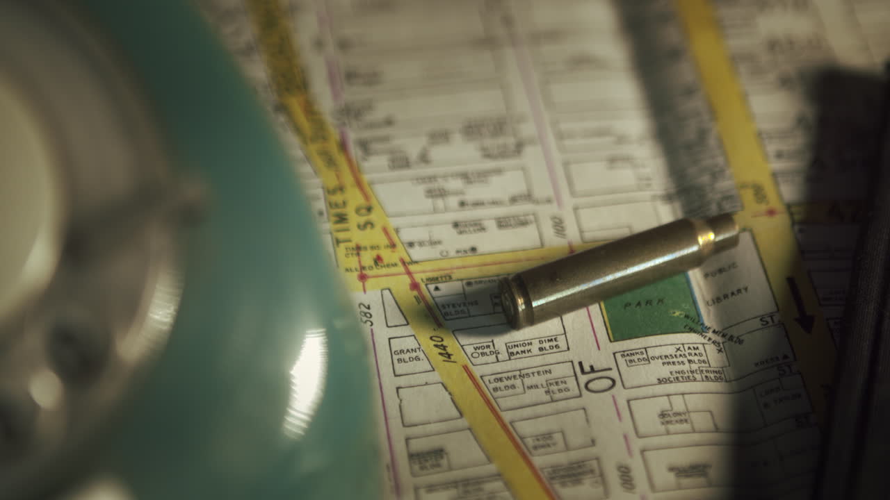 Transizione cinematografica con messa a fuoco a cremagliera da una mappa di carta a un telefono retrò verde. Scatto concettuale per lavoro investigativo anni '70 o mistero di un caso irrisolto.