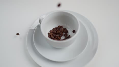 granos de café cayendo en una taza blanca en cámara lenta