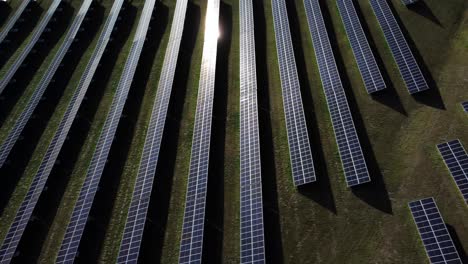 side drone shot of the solar panels field reflecting sun rays