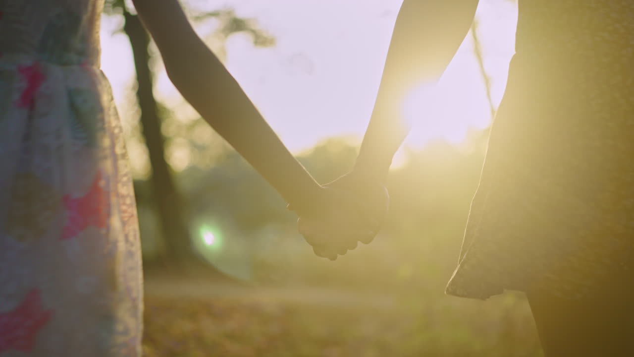 Girls holding hands at sunset