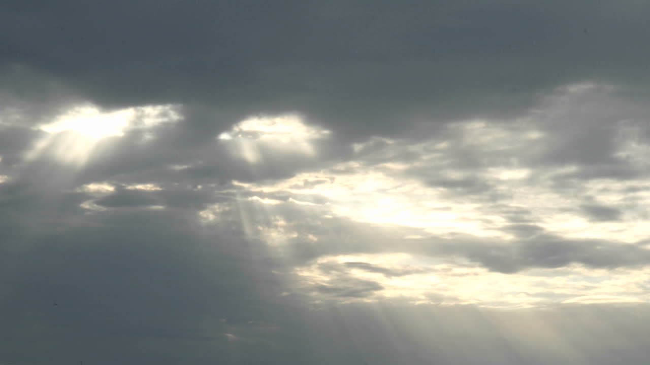 солнечные ореолы просвечивают, когда яркое золотое солнце исчезает за темными облаками