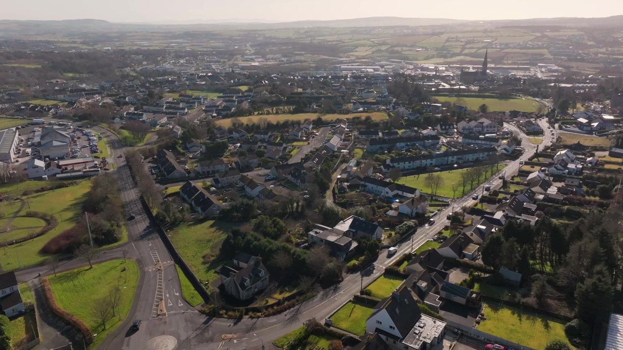Una ripresa aerea cinematografica che mostra l'autentico paesaggio suburbano e le verdi periferie di Letterkenny, Donegal, Irlanda, durante un pomeriggio luminoso