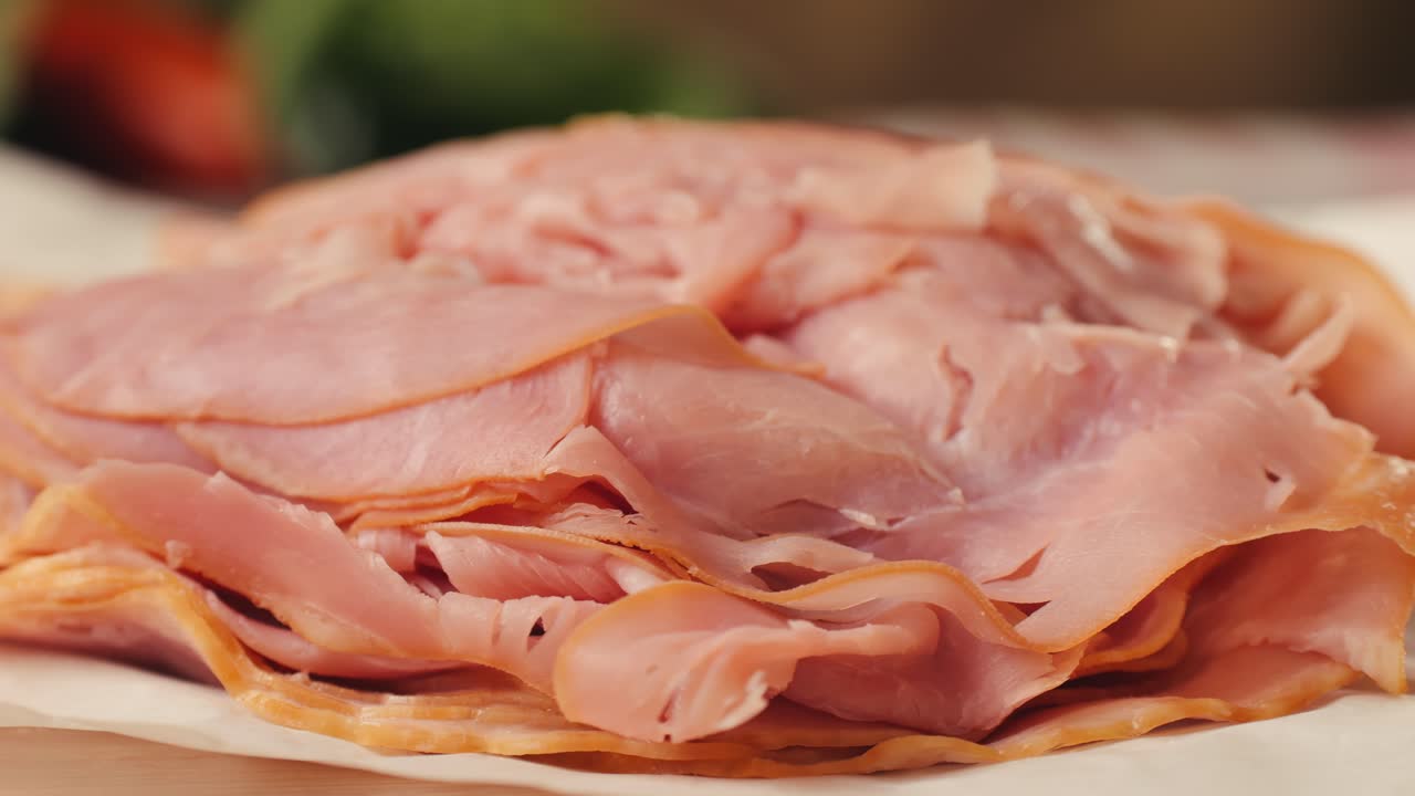 Ham italian mordatella, man Slices Of Traditional Italian antipasti mortadella sausage on a wooden cutting board, close up macro of chicken or turkey jamon, fat breakfast dish.