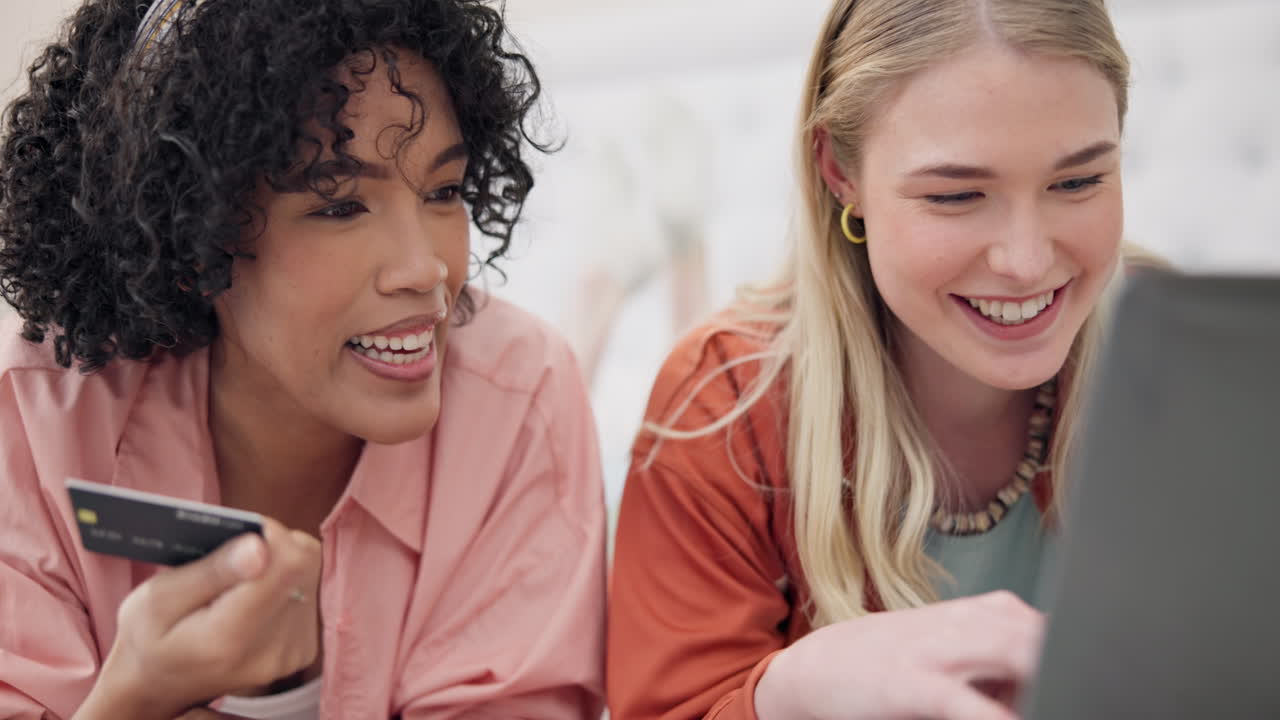 Credit card, laptop and women friends on a bed