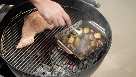 chef stirring grilled and seasoned potatoes over a hot grill