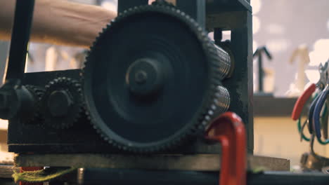 jeweler turns tool lever processing gold on table closeup