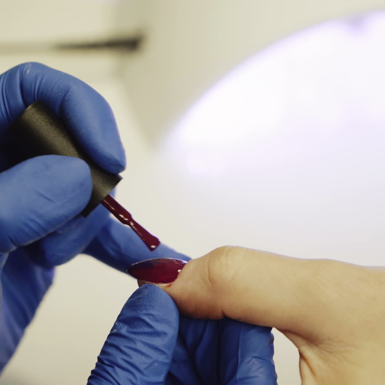 Manicure. Polishing nails with red nail polish in the beauty salon. Hand care in the spa. Close-up Square video