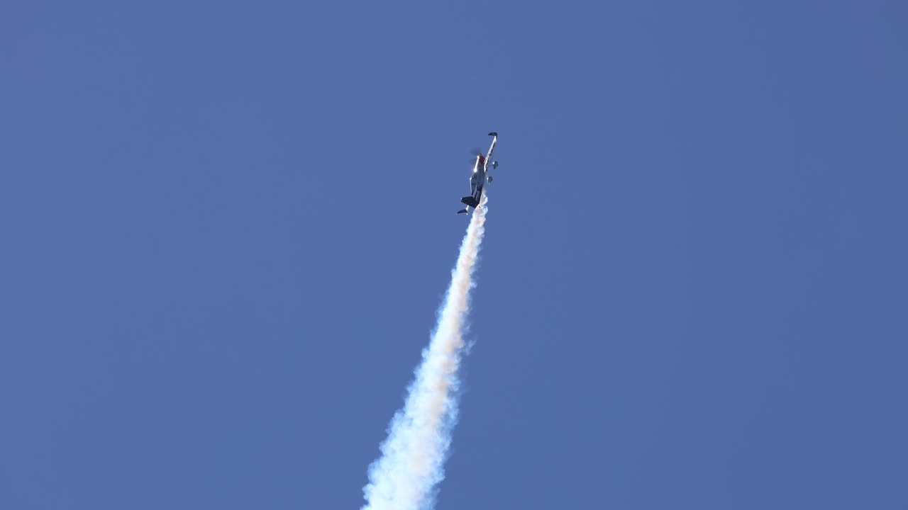 avión de acrobacias ejecuta maniobras con rastros de humo
