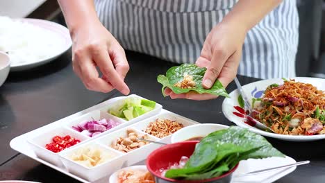 손으로 전통적인 태국 미앙 을 조심스럽게 포장하는 맛있는 잎