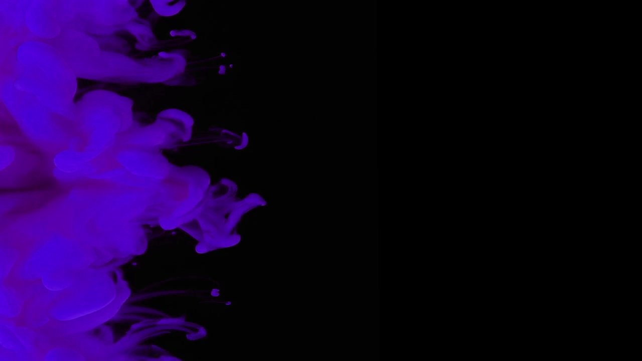 Inchiostro viola che si diffonde nell'acqua su sfondo nero