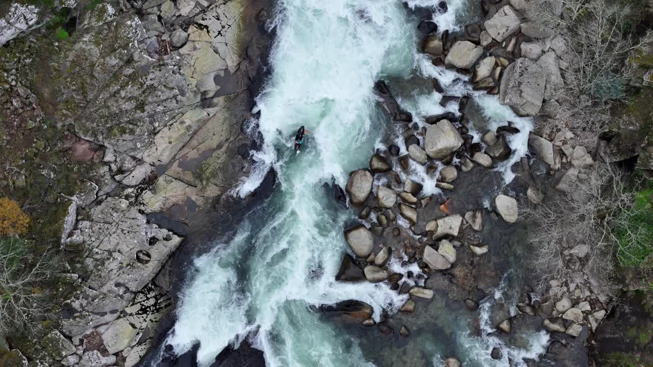 Kayakista nero che rema in rapide d'acqua bianca in un fiume pulito in Europa