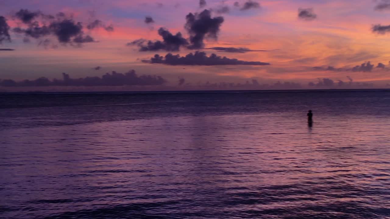Grafico tramonto viola con silhouette di pescatore solitario in riviera