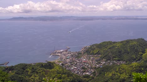 High-Up-View-Over-Hama-Kanaya-Coastal-Town-At-The-Foot-Of-Lush-Mountains-In-Chiba,-Japan---Wide-Shot