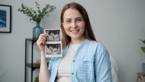 happy pregnant woman showing ultrasound
