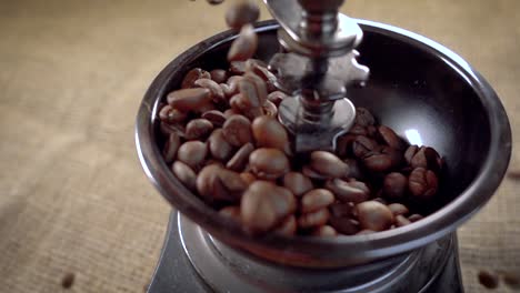 coffee beans fall in the old grinder. slow motion with rotation tracking shot.