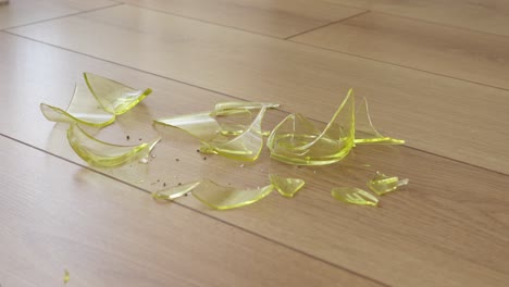 broken yellow glass on wooden floor