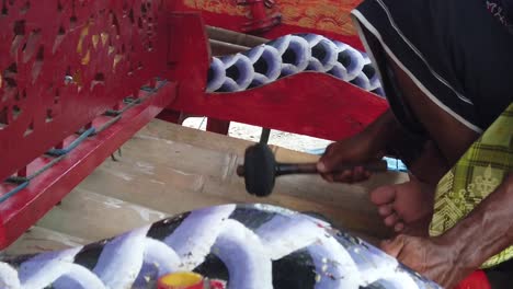 primer plano de las manos del músico gamelan tocando el instrumento de bambú jegog de bali, indonesia, regencia de jembrana, adornos coloridos