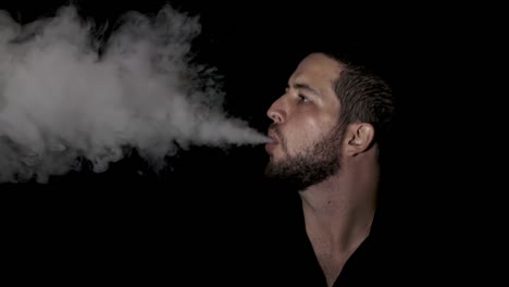 man smoking electronic cigarette vapor on black background