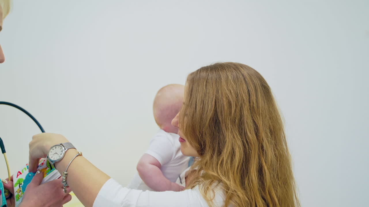 Professional pediatrician examining infant. Pediatrician examining little baby in clinic
