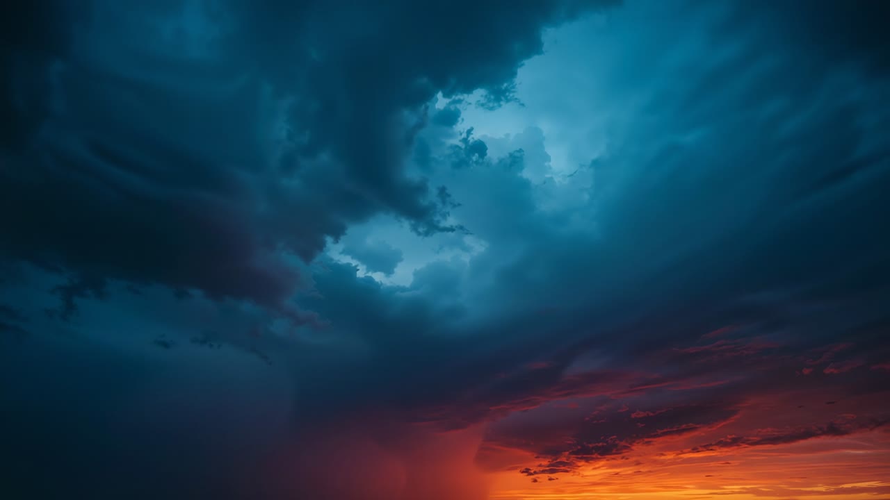 Advancing storm clouds thickening over sunset sky as sinking sun highlighting swirling masses