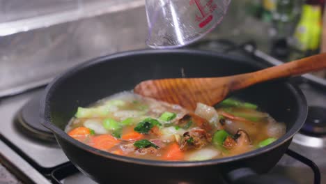 adding-chicken-stock-to-sauce