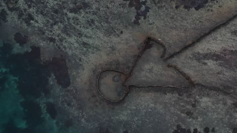 Aerial-view-of-a-fish-trap-set-up-in-a-large-tropical-lagoon-near-a-Pacific-Island-village