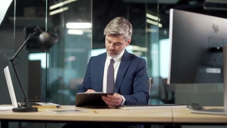 senior business man signs a approval document in the office. mature gray successful banker or lawyer businessman reading and signing business partnership contract