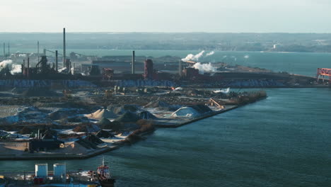 industrial harbor with smokestacks and clear skies, daylight, aerial view