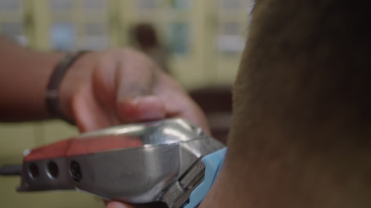 Hands of Barber Trimming Neck Hair of Client with Clippers