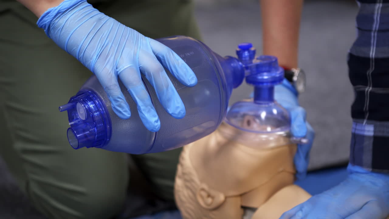 Cardiopulmonary resuscitation. Training demonstration of a chest compression and breathing on a dummy. Close-up.