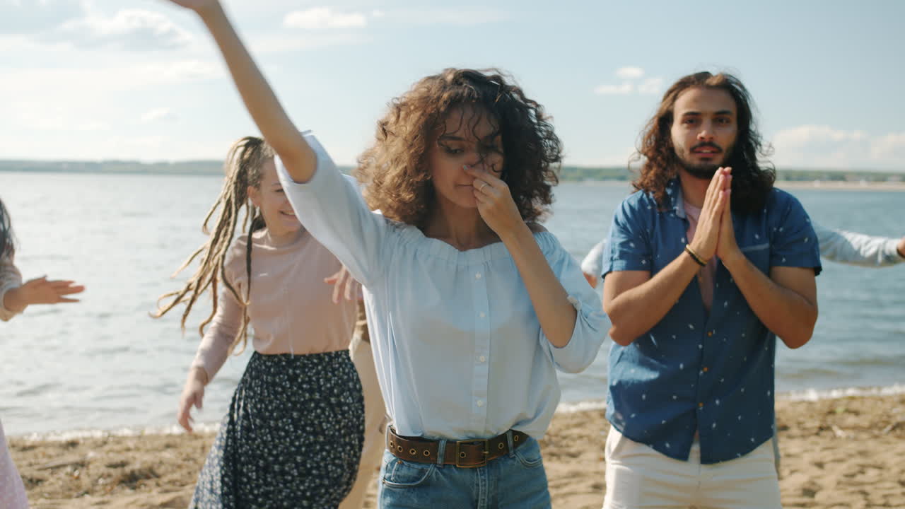 amigos bailando en la playa.