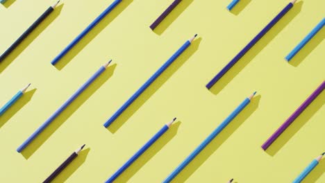 video of multi-colored crayons in a row on a yellow background