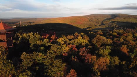 backward aerial of passing by hárs hill lookout point in autumn forest