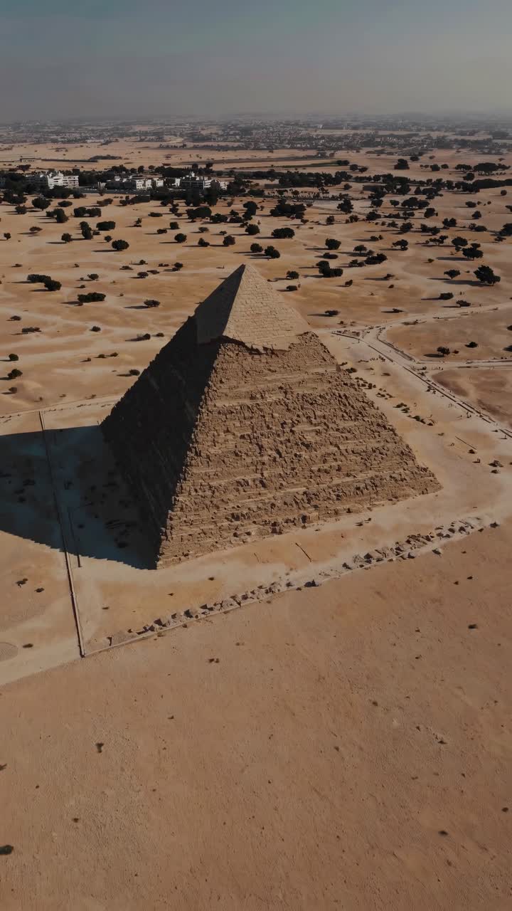 Aerial video captures a pyramid in a vast desert landscape, showcasing its grandeur from a high