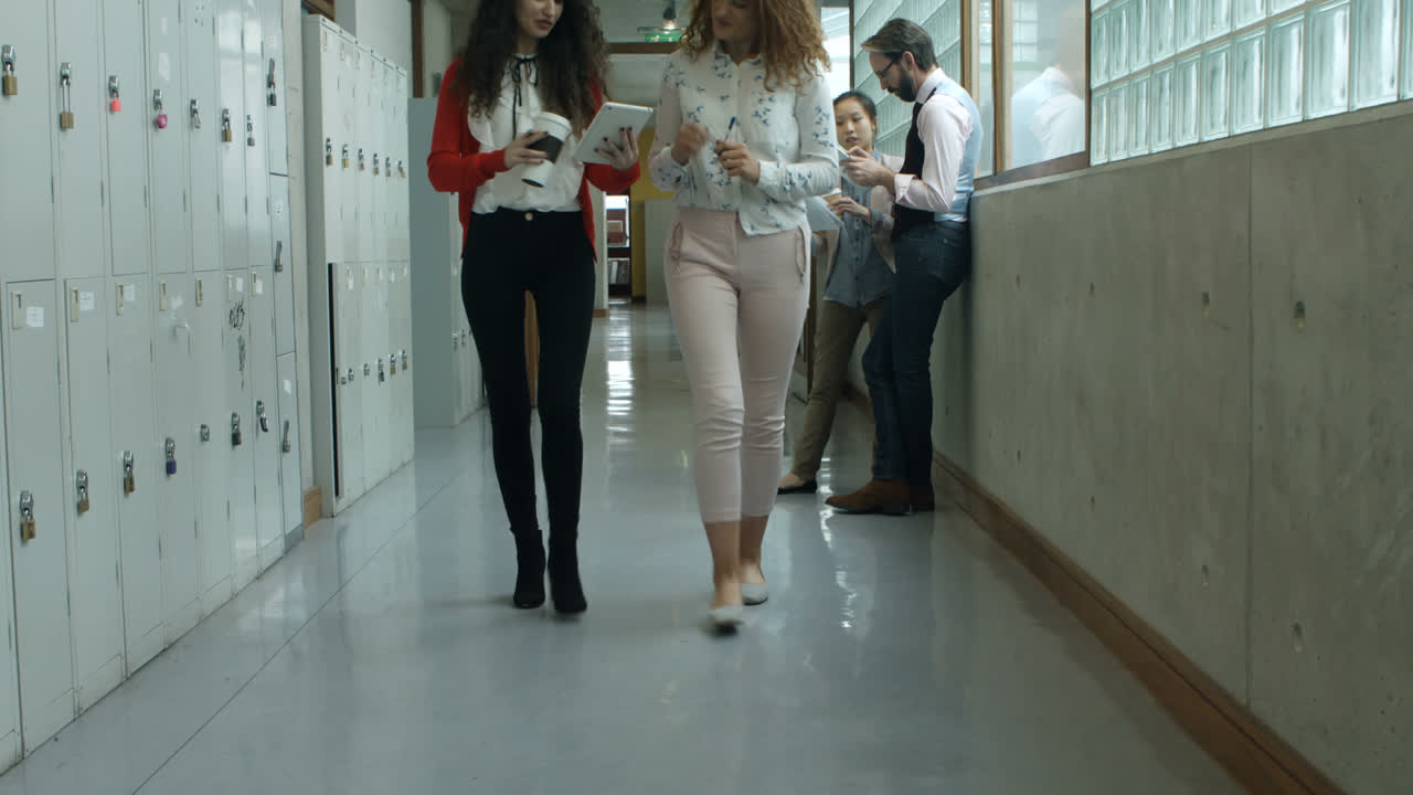 colegas discutiendo sobre una tableta digital en el corredor 4k