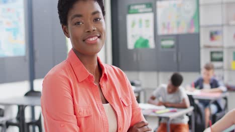 Portrait-of-diverse-female-teacher-and-schoolchildren-at-desks-in-school-classroom