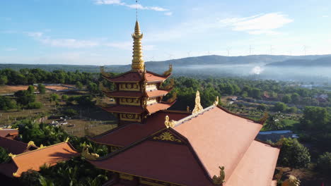 aerial circle view over a temple in a tropical paradise jungle with mist over fields