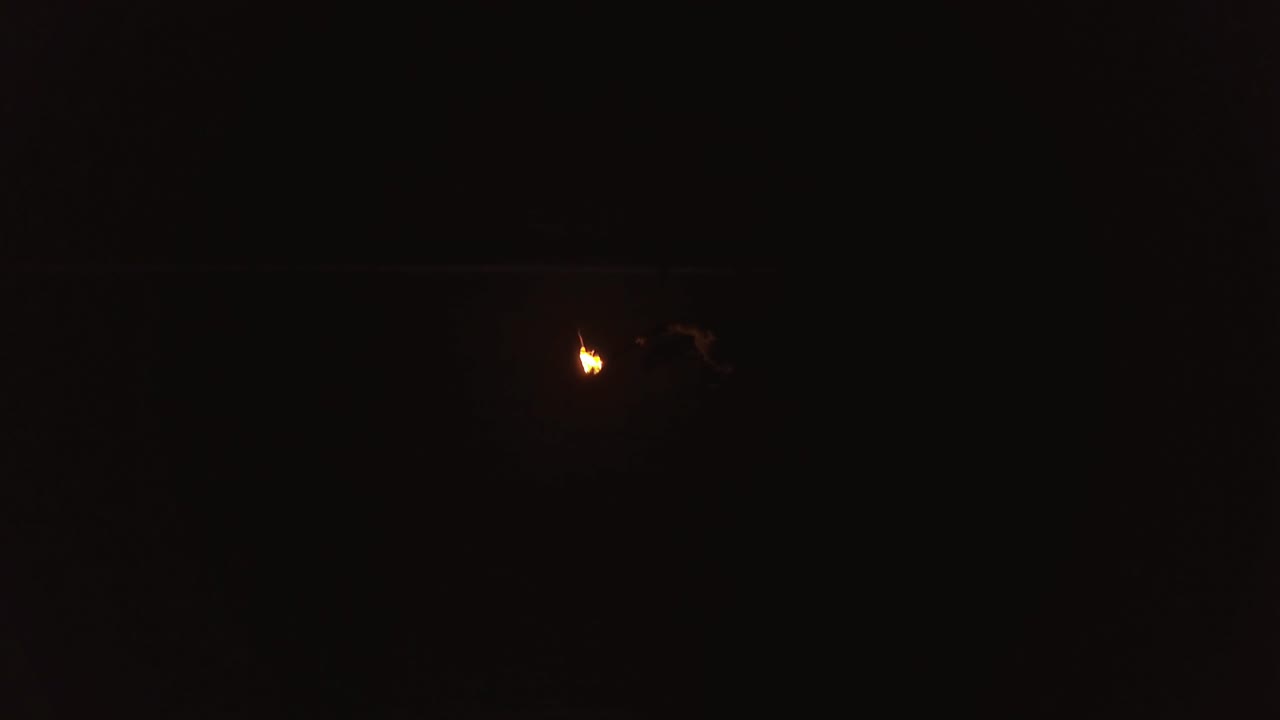 젊은 금발 남자가 불의 큰 흐름을 호흡하여 불공을 만들고 있습니다.