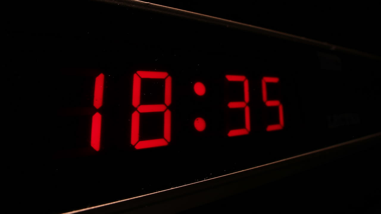 Red digital display clock with 24-hour time shows time flying by, timelapse zoom