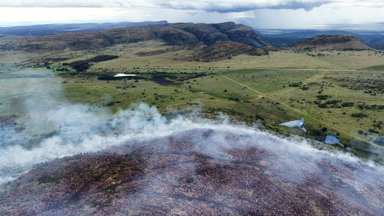 Aerial view of smoky hillside edge above dramatic valley landscape