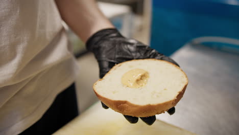chef using spoon to spread mayonnaise on the burger bread