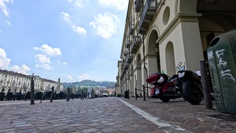 motorcycle parked on cobblestone street in turin